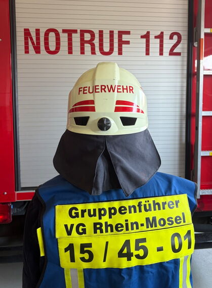 Gruppenführer mit Weste und Helm von Hinten