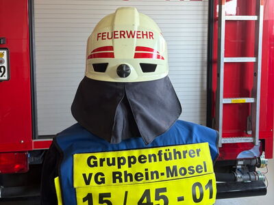 Gruppenführer mit Weste und Helm von Hinten